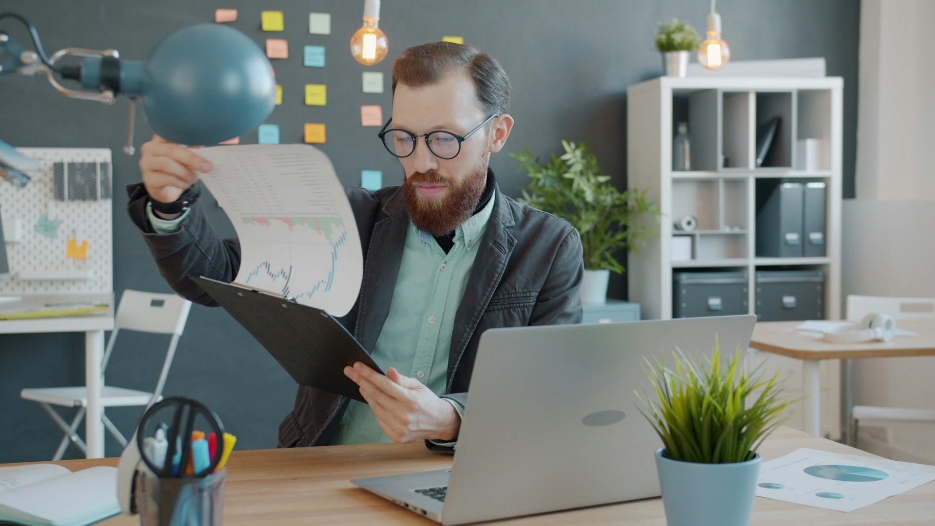 Man in office reviewing documents at desk documents